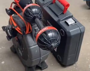 A Ridgid inspection camera system with cables and two camera heads is placed on the floor next to a black Ridgid carrying case with a red handle. | High 5 Plumbing, Heating & Cooling