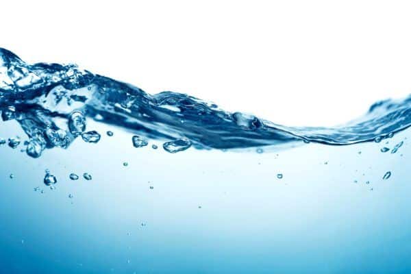 Clear blue hot water with small bubbles and ripples, photographed close up against a white background. The image captures the motion and fluidity of the water as it undulates, reminiscent of happy moments in households. | High 5 Plumbing, Heating & Cooling